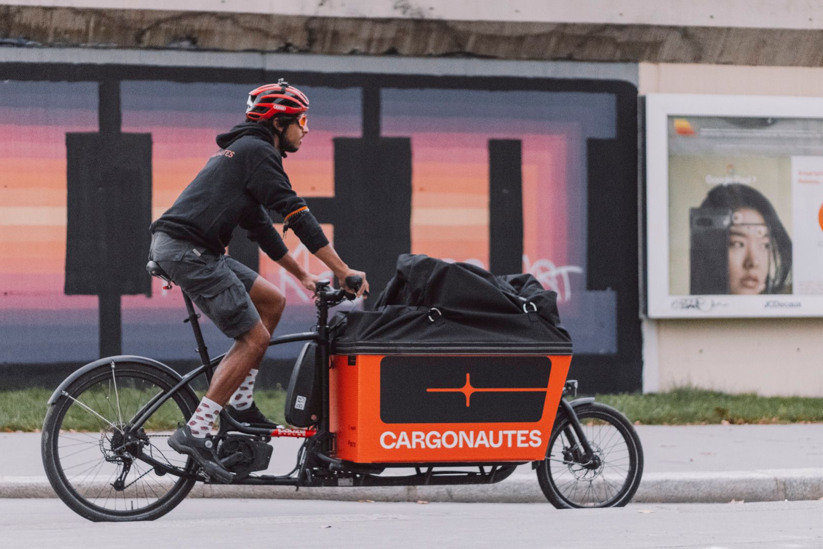 Un coursier sur son vélo cargo, entrain d'effectuer une opération spéciale