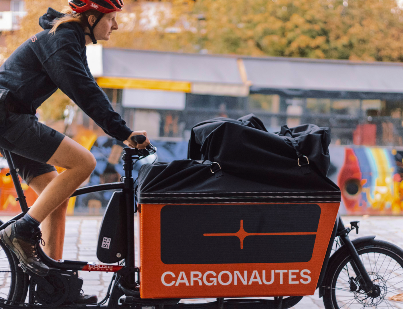 Une coursière de chez Cargonautes sur son vélo en pleine tournée