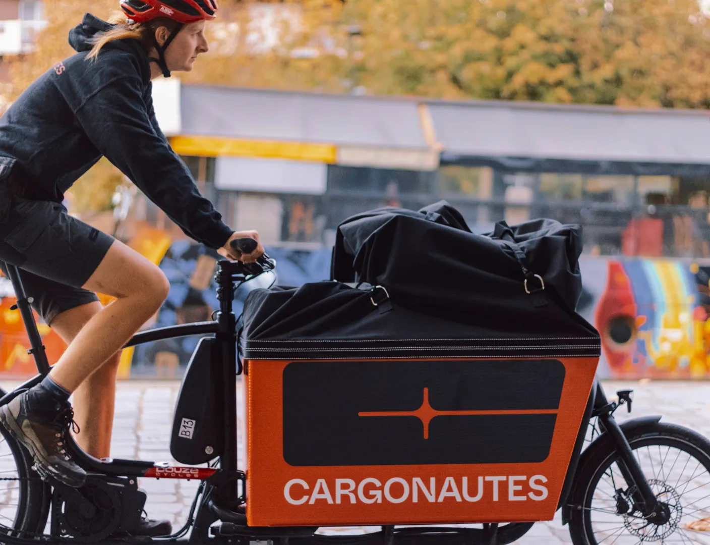 Une coursière de chez Cargonautes sur son vélo en pleine tournée.
