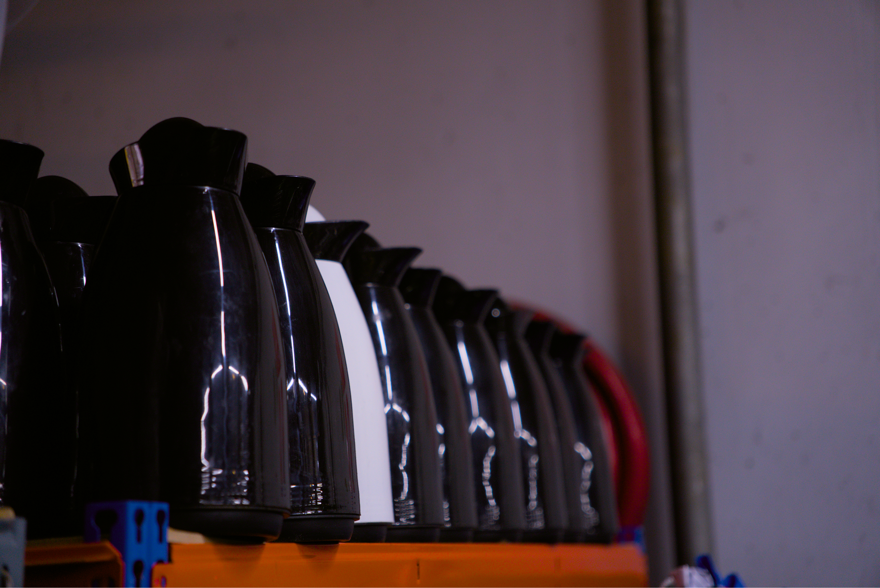 Des thermos vides ramassés par les coursiers et regroupés sur un étagère.